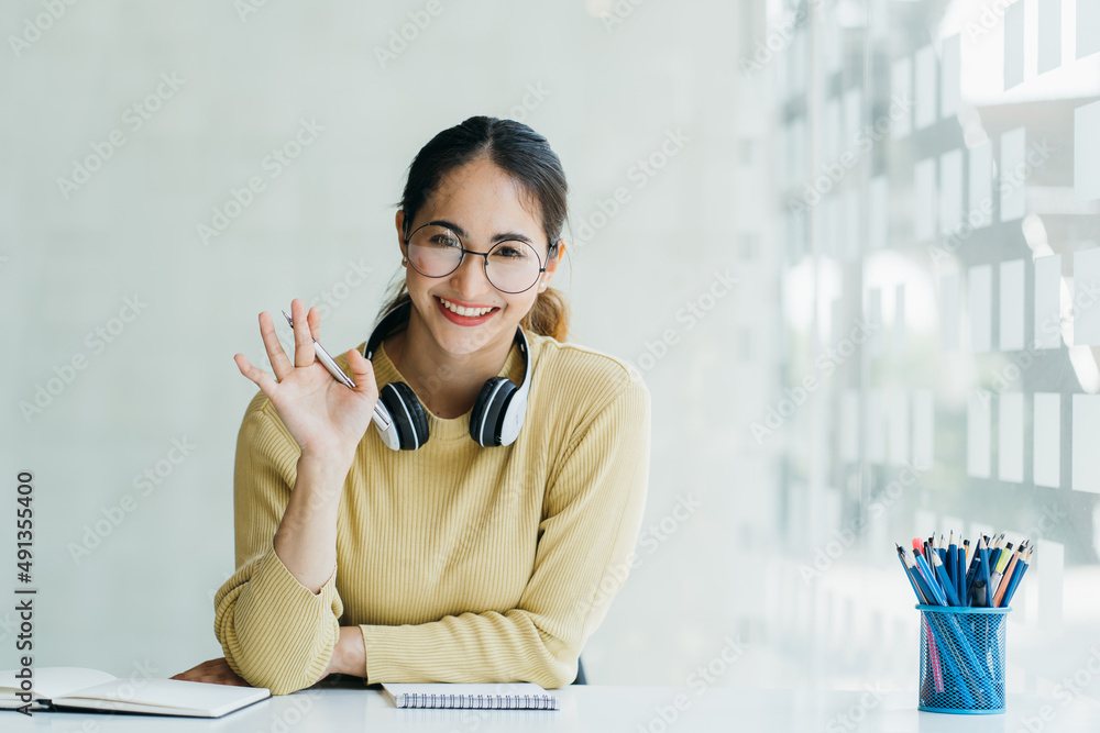 戴着耳机、带麦克风的快乐年轻女性参与教育视频电话会议对话