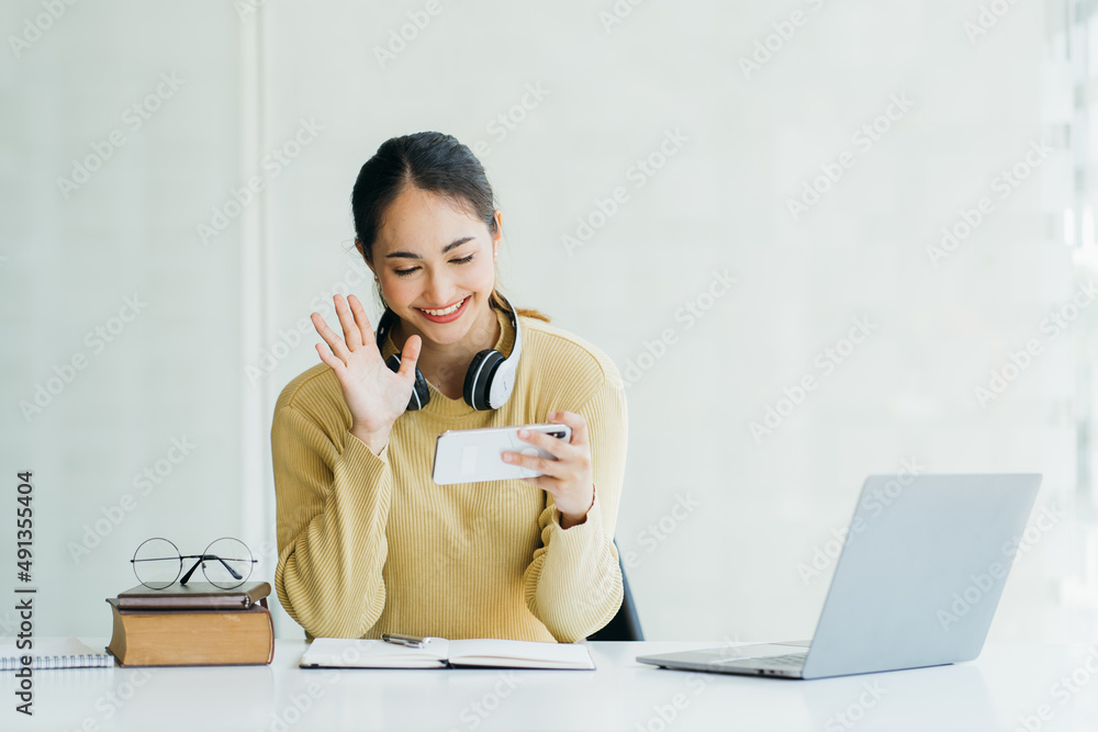 戴着耳机、带麦克风的快乐年轻女性参与教育视频电话会议对话