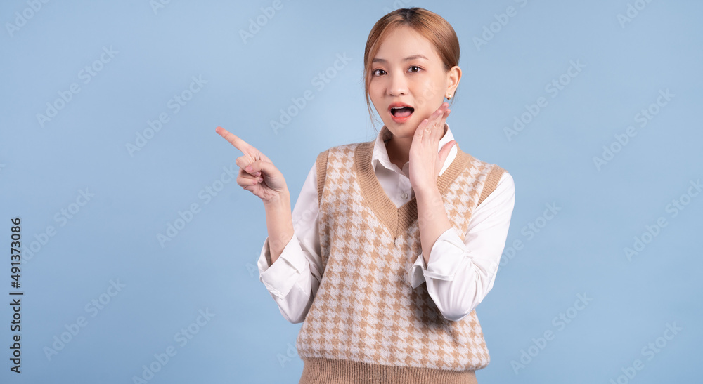 Young Asian teenager on blue background