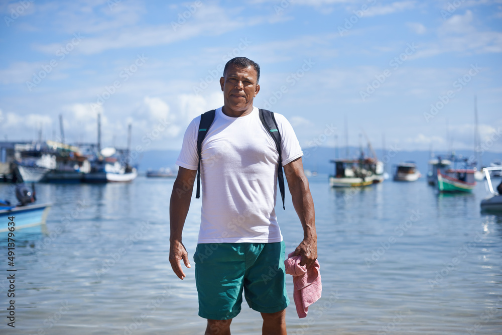 Fishing is my life. Portrait of a fisherman standing in shallow water in the harbor.