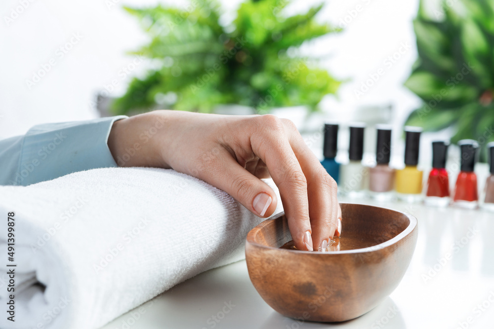 Closeup female hands in wooden bowl with water