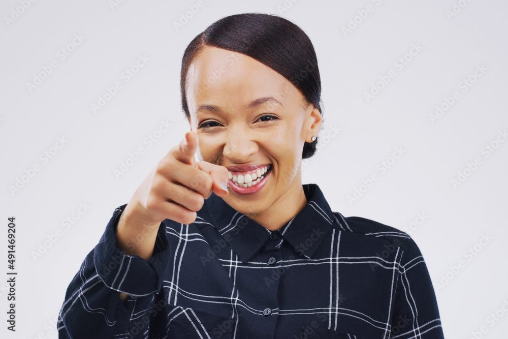 I see you over there. Portrait of a beautiful young woman pointing to the camera against a grey back