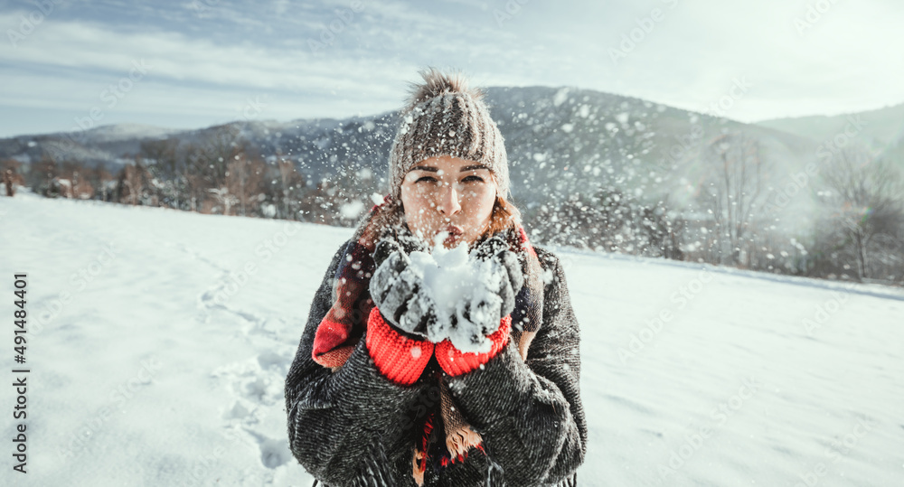 美丽的女孩吹雪快乐的冬天