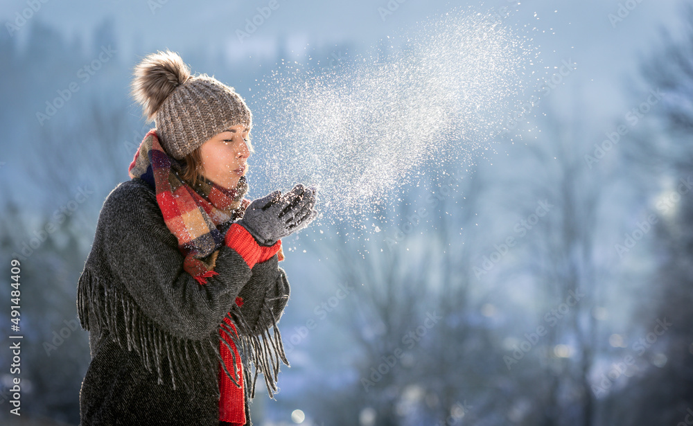 美丽的女孩吹雪快乐的冬季时光