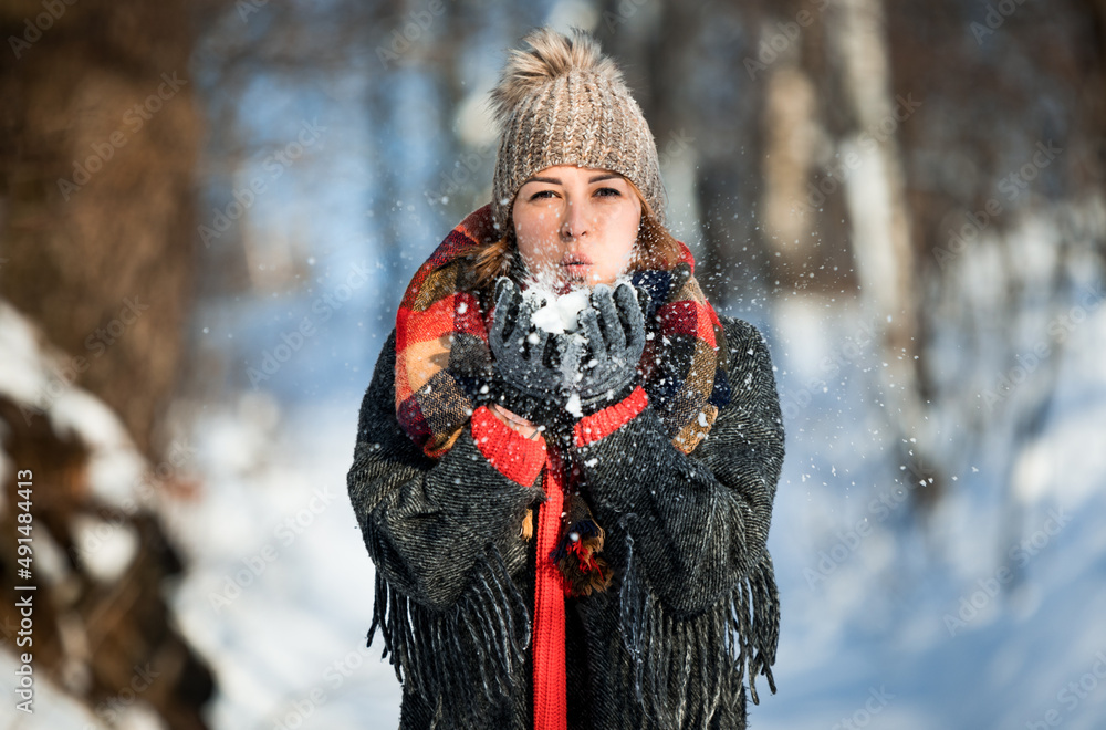 美丽的女孩吹雪快乐的冬季时光