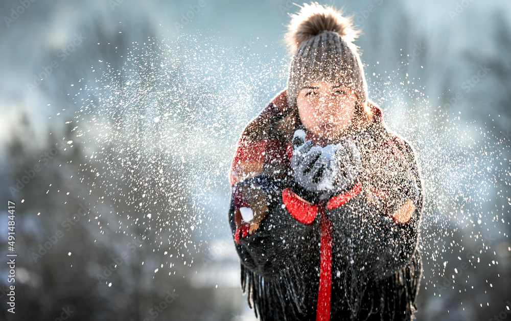 Beautiful girl blowing snow happy winter time