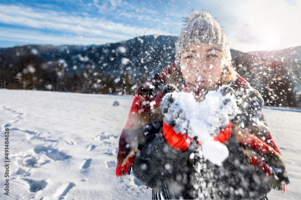 Girl blowing on snow magic frozen flakes in the air