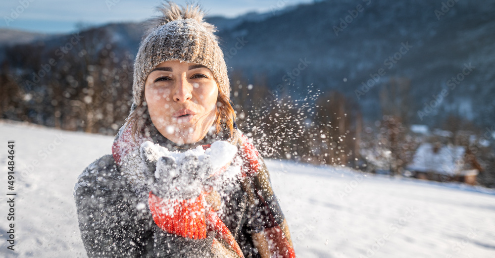 女孩在雪地上吹魔法，空中飘着冰冻的雪花