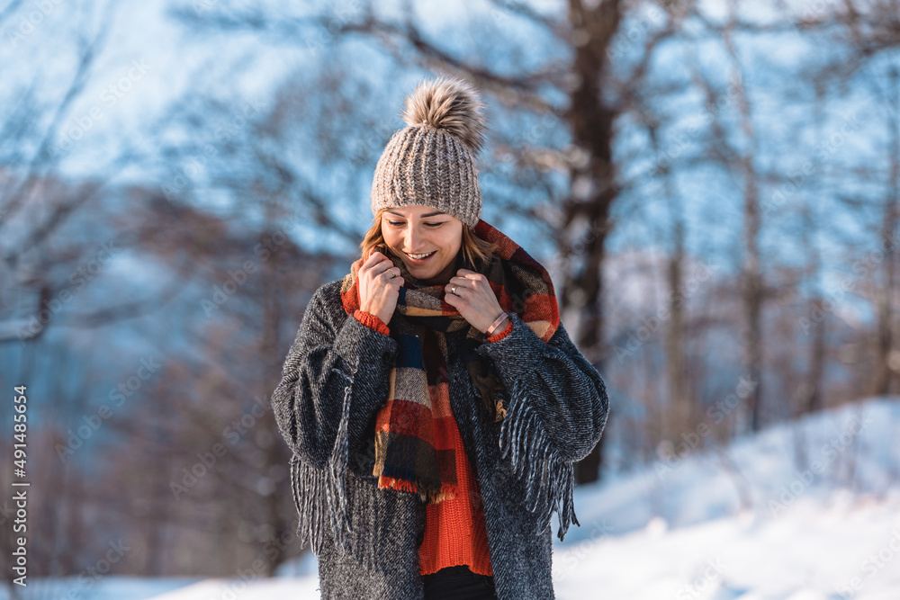 Wintertime smiling woman among snowy landscape