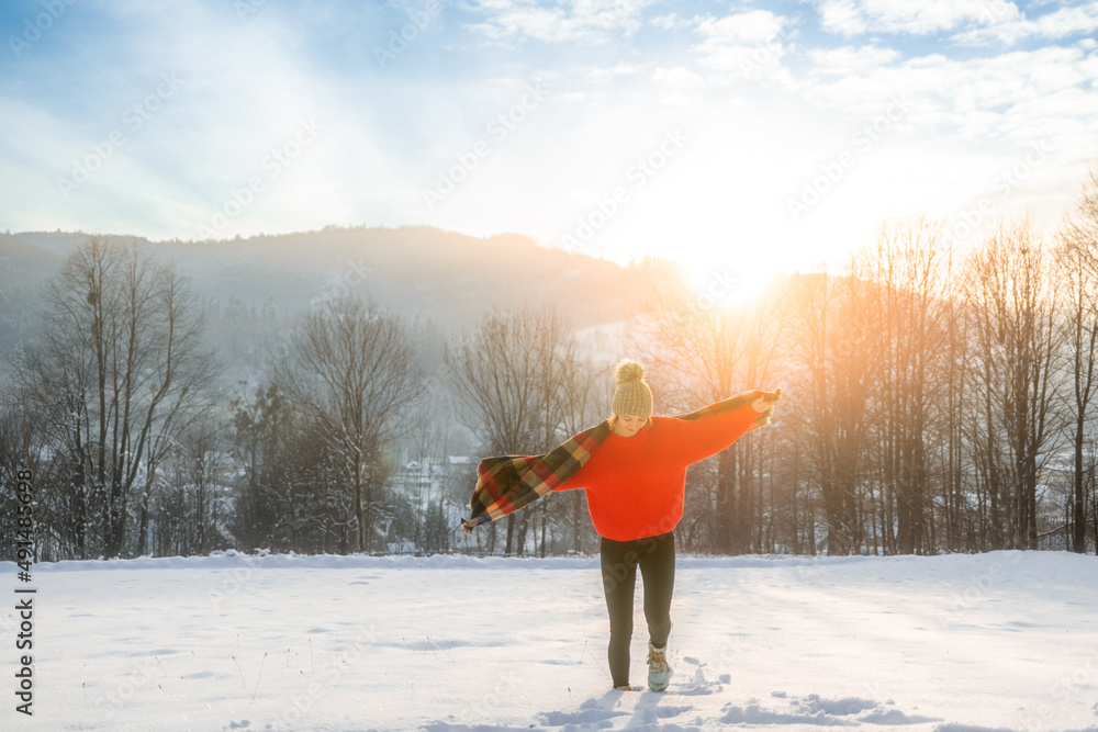 Young woman in the winter time walks among snow