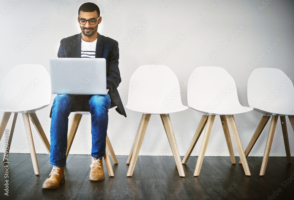 Preparing an interesting introduction before his interview. Shot of a young businessman using a lapt