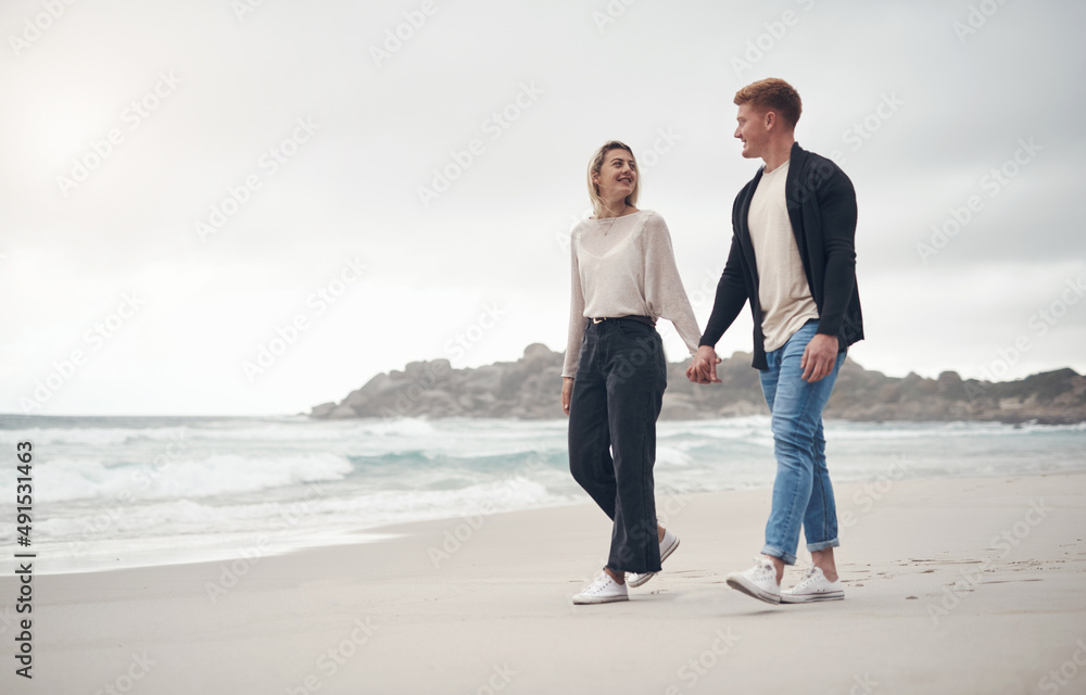 The beach is our favourite place. Shot of a couple holding hands while strolling on the beach.