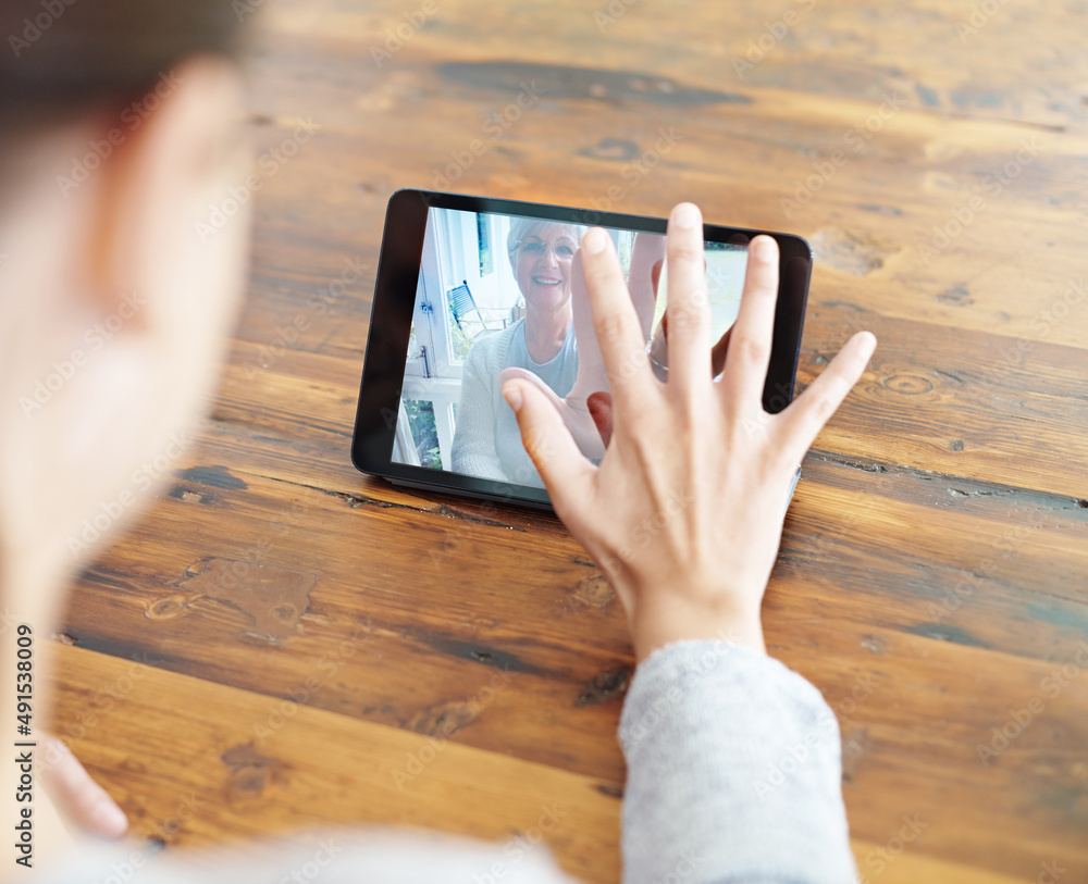 I miss you mom. A young woman using a digital tablet for a video call with her family.