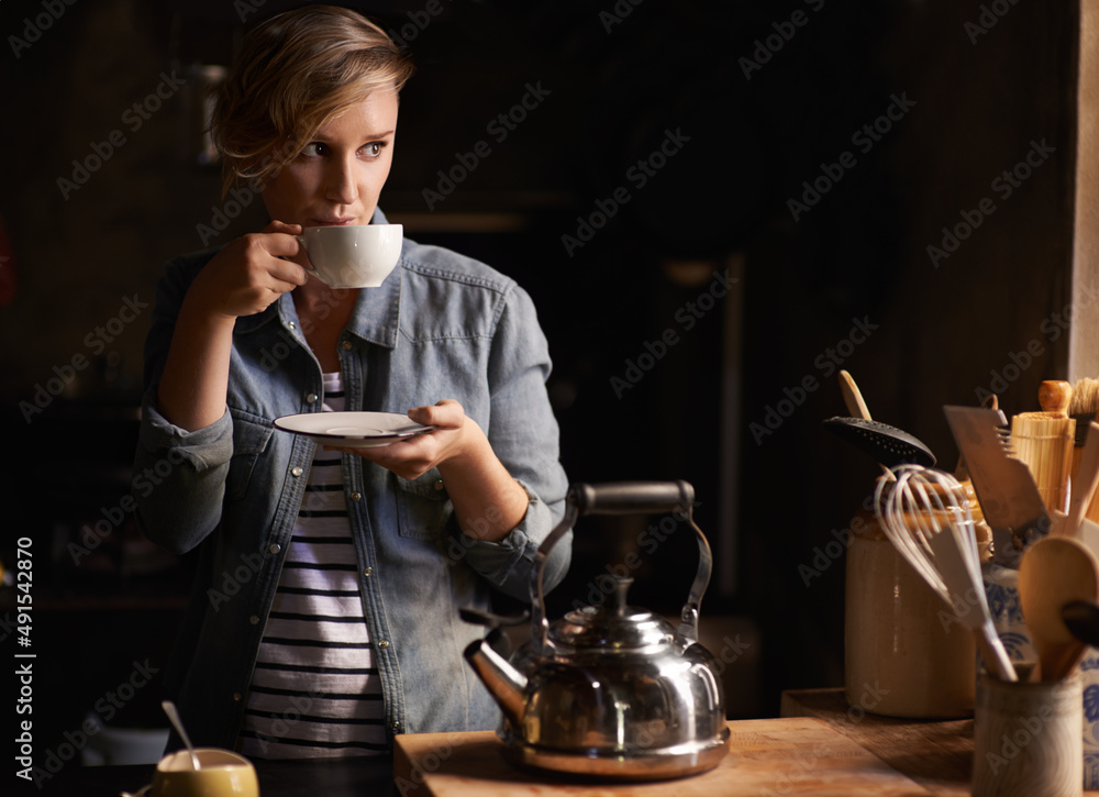 一段安静的时间，喝杯茶。一个漂亮的年轻女人在厨房喝茶的镜头。