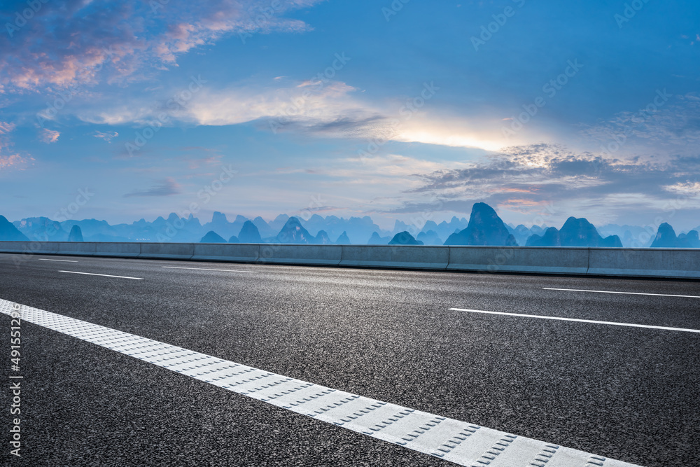 日落时的沥青公路和山脉自然风光。道路和山脉背景。