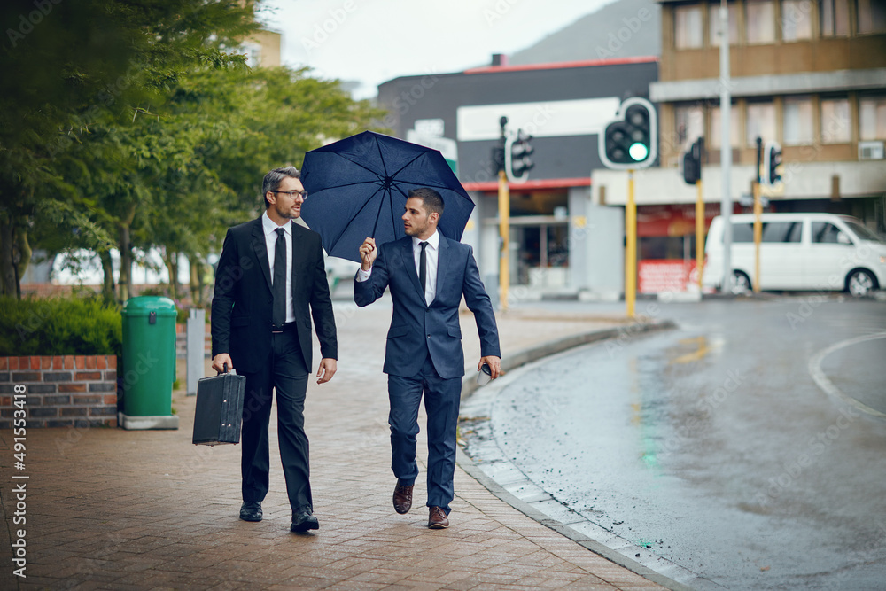 Seeking new opportunities in the city. Shot of two corporate businessmen travelling through the city