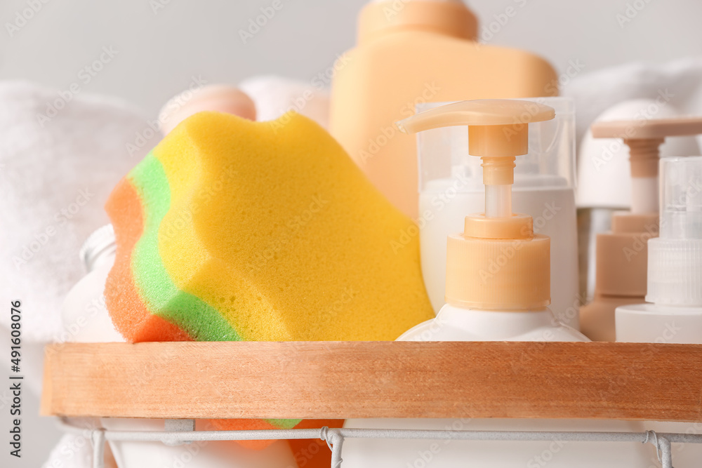 Basket with cosmetic products and bath sponge, closeup