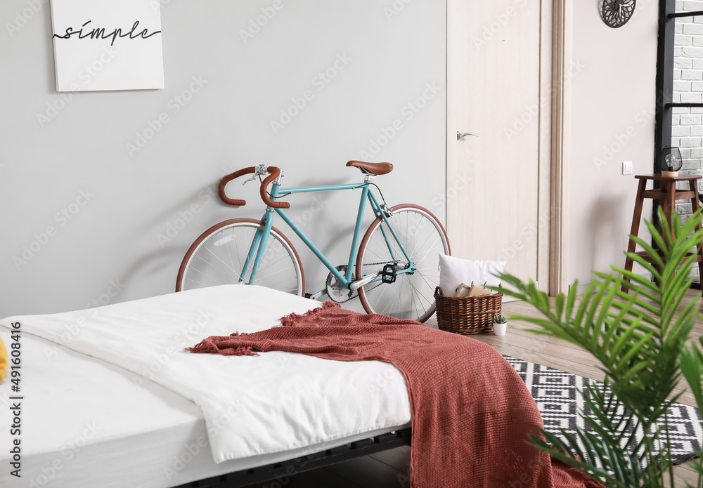 Bicycle near grey wall in modern bedroom interior