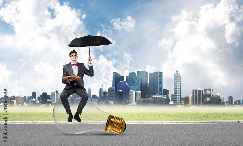 young businessman with umbrella and a book