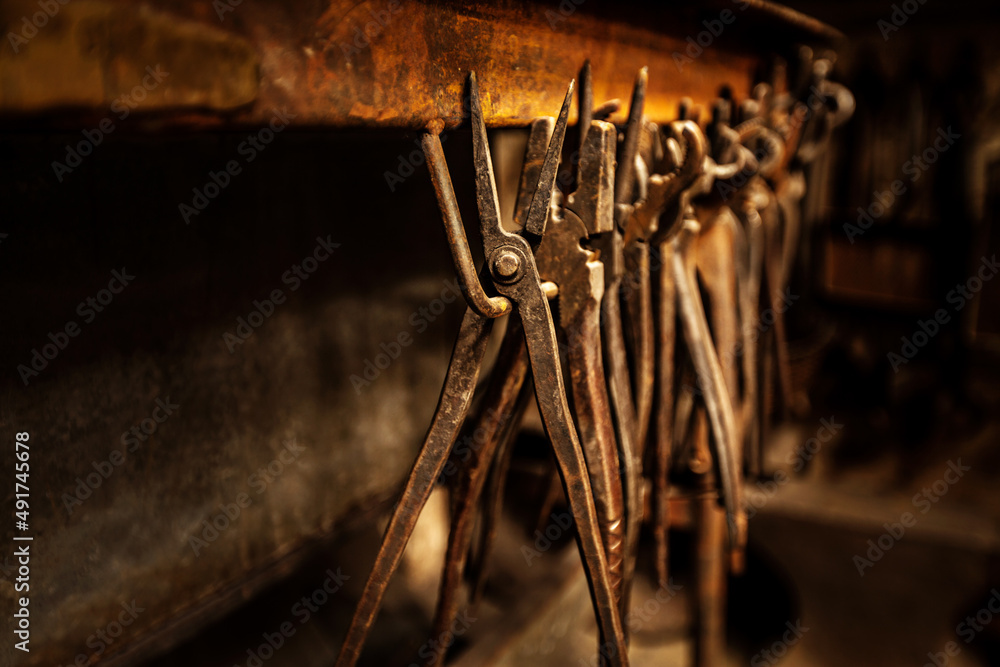 Tools of the trade. A range of pliers and tongs hanging in a workshop.