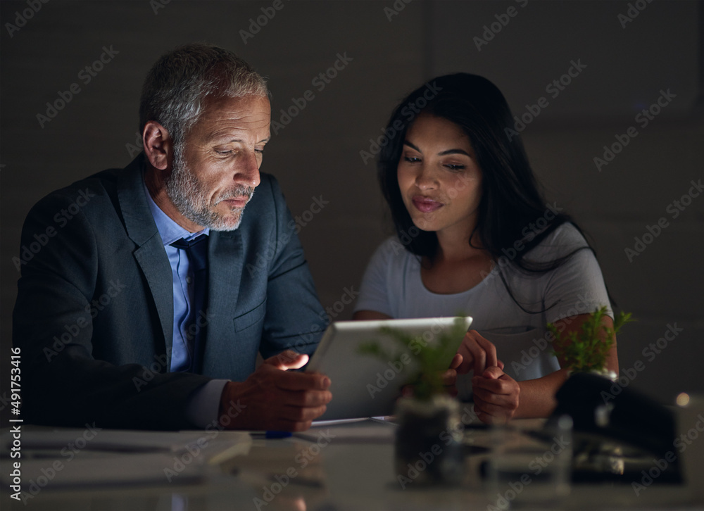 They make sure everything is right before heading home. Shot of two colleagues using a digital table