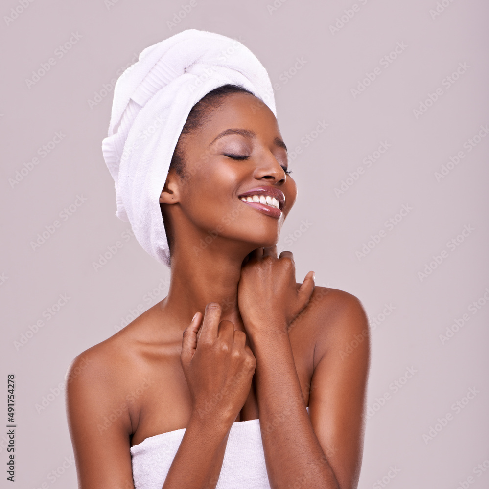 Skin that begs to be touched. An isolated studio shot of a beautiful young woman wearing a towel on 