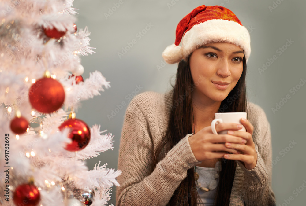 Drinking cocoa and thinking about Christmas. Cropped shot of an attractive young woman enjoying a ho