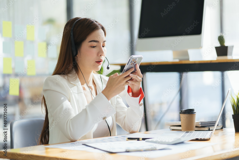 自信的年轻女商人戴着耳机，在视频上与客户讨论项目细节