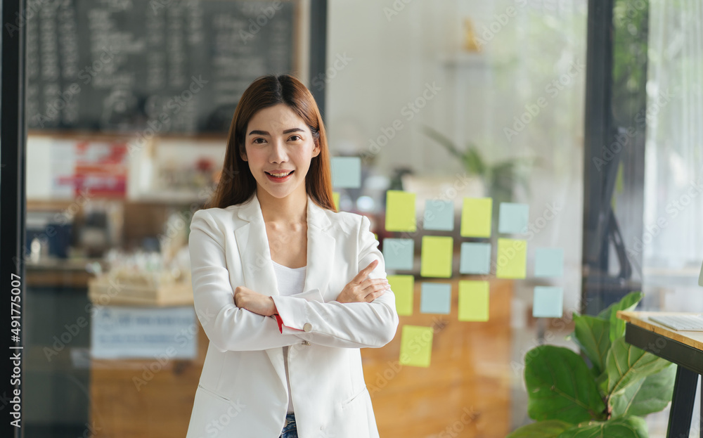 办公室里年轻漂亮的亚洲商业女性的肖像。双臂交叉