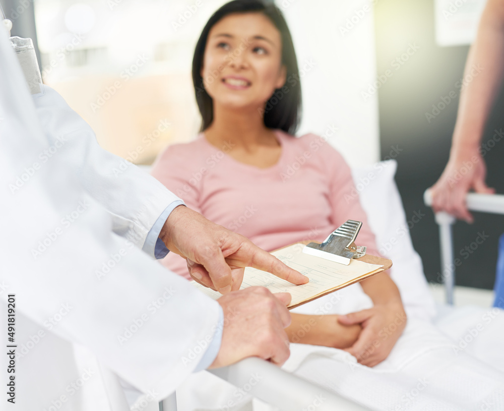 I think youre ready to be discharged. Shot of a young patient looking up at her unidentifiable docto