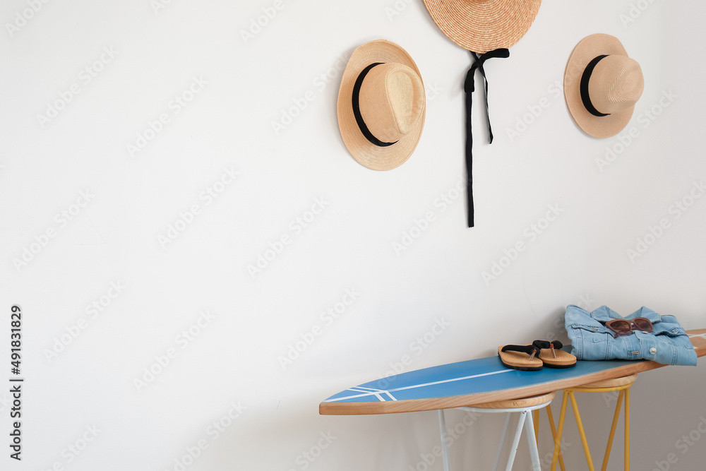 Interior of modern stylish room with surfboard, hats and female accessories