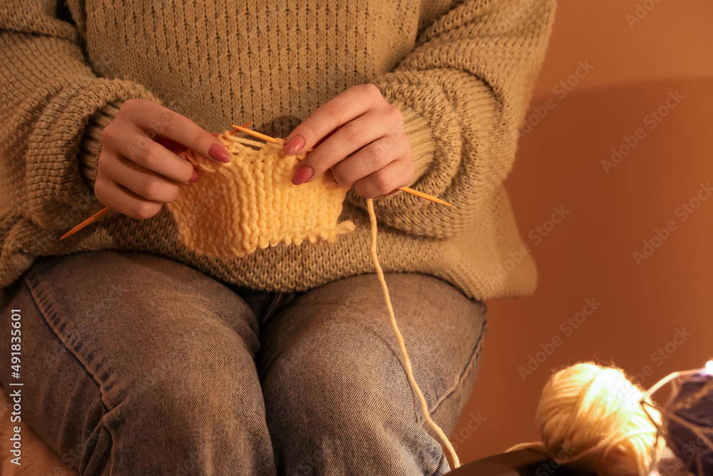 Young woman knitting warm clothes at home, closeup