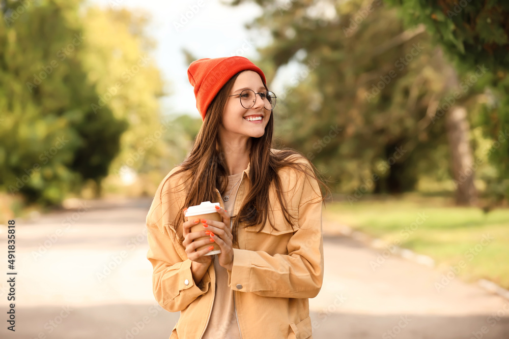 Beautiful young girl with cup of coffee outdoors