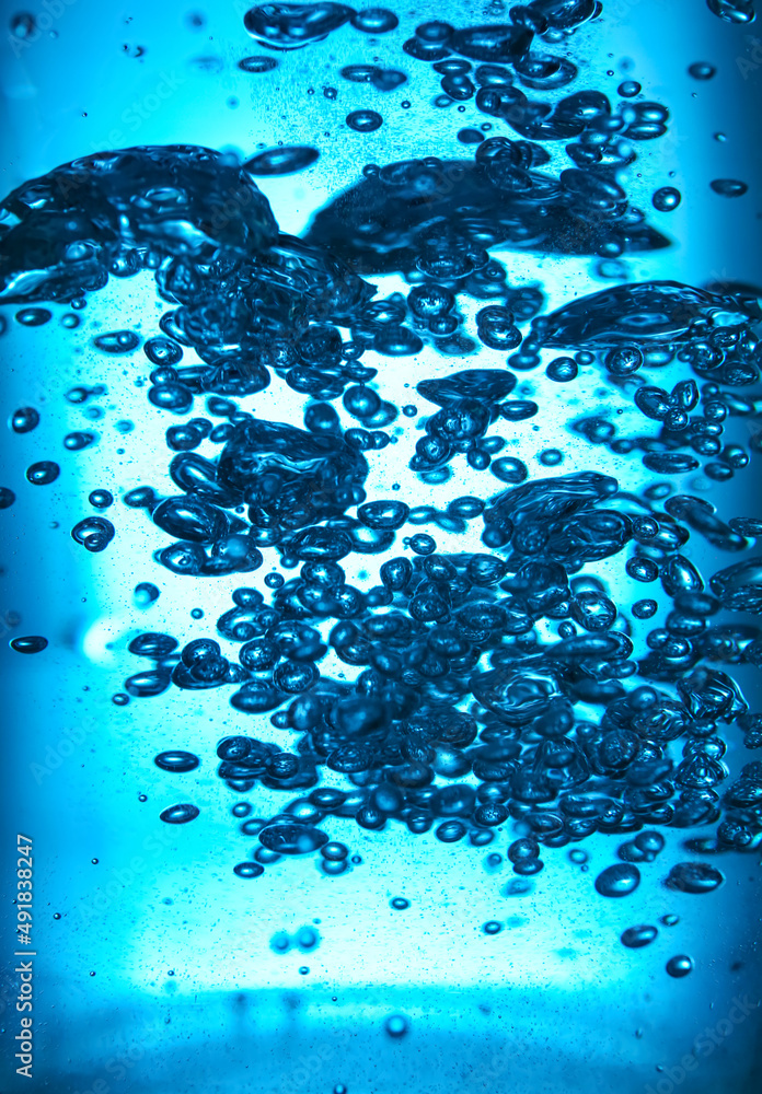 Clear water with bubbles on blue background, closeup