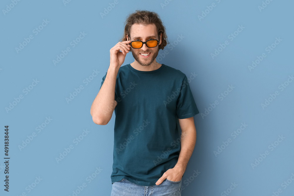 Handsome young man in stylish t-shirt on blue background