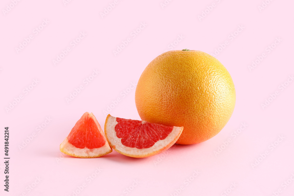 Tasty ripe grapefruit on pink background