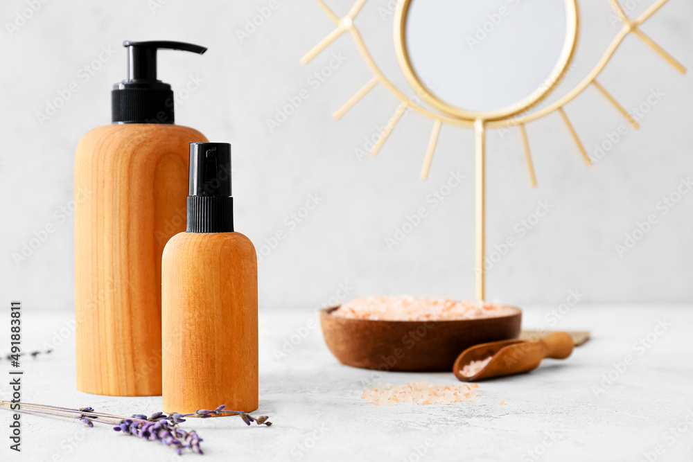 Bottles of natural cosmetic products on light background