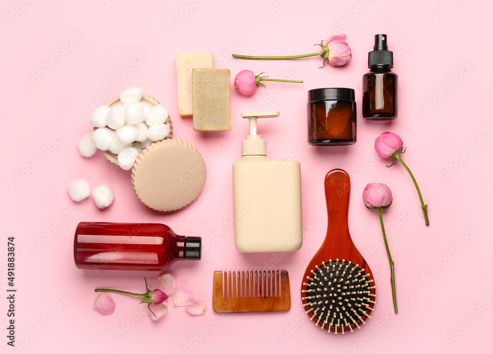 Set of bath supplies and rose flowers on pink background