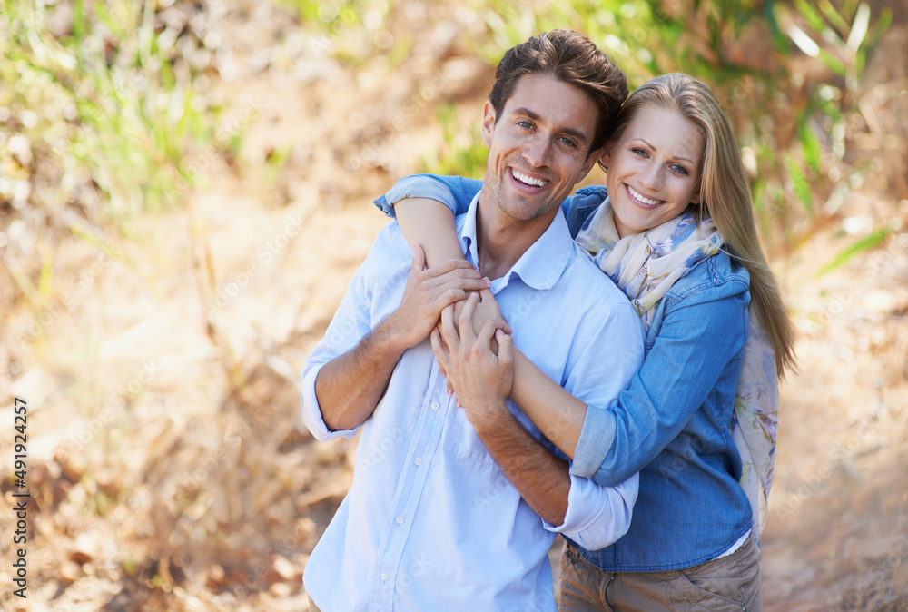 Young and so in love. A cropped view of a romantic young couple standing together outdoors.