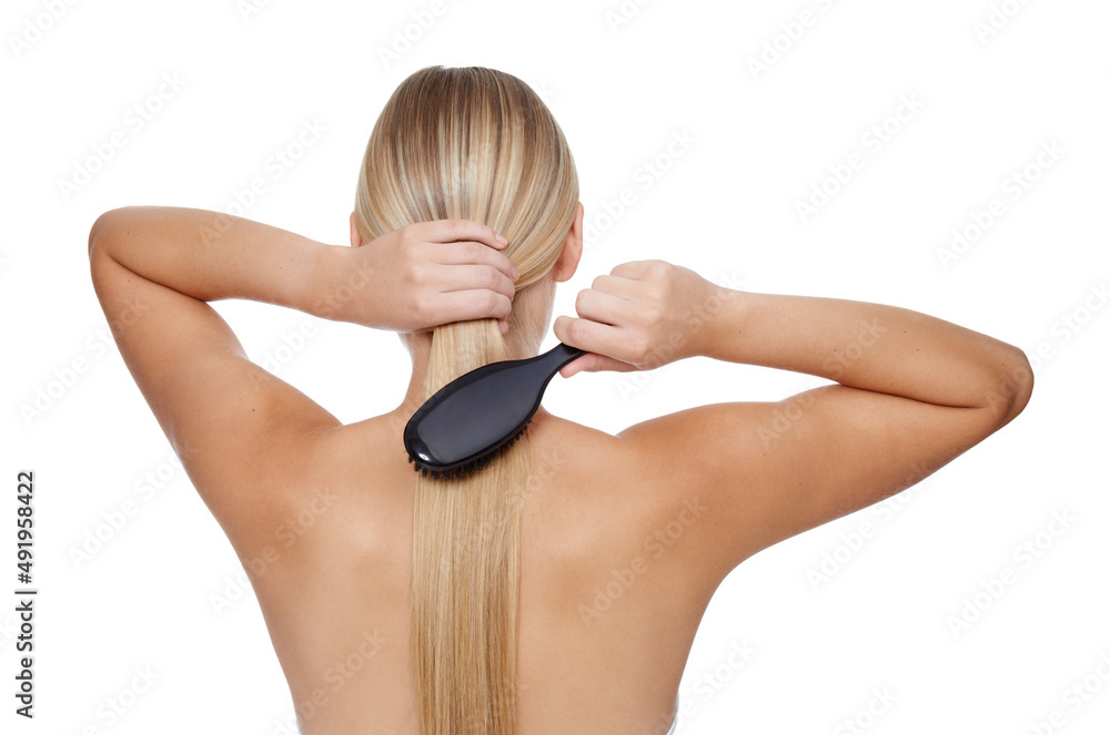 Combing her hair to keep it healthy. A gorgeous young woman showing off her hair.