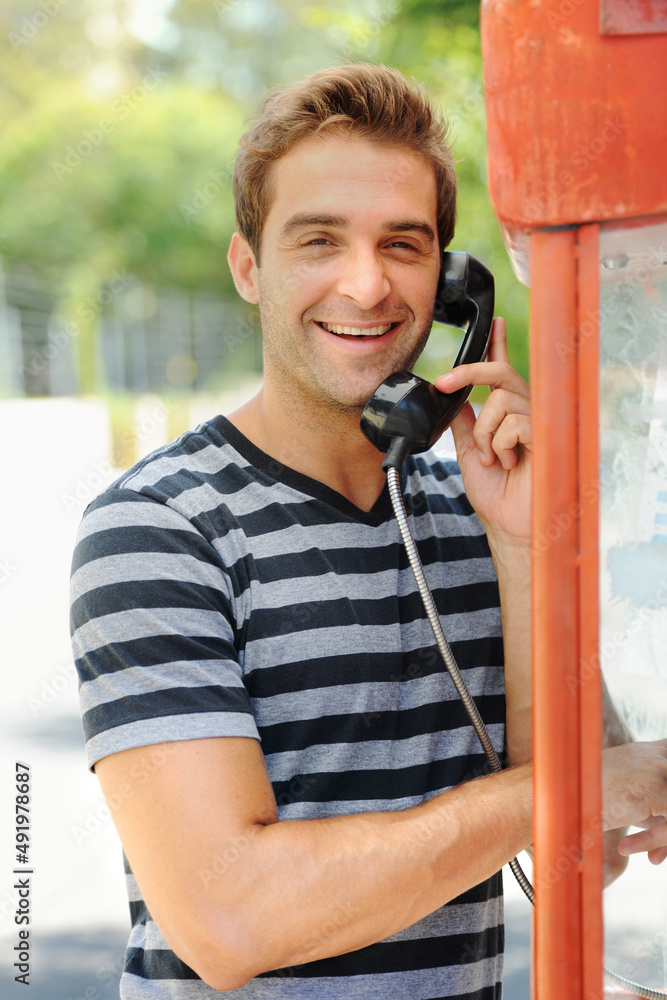 Sharing his adventures - calling home. A handsome young man smiling and having a conversation on a p