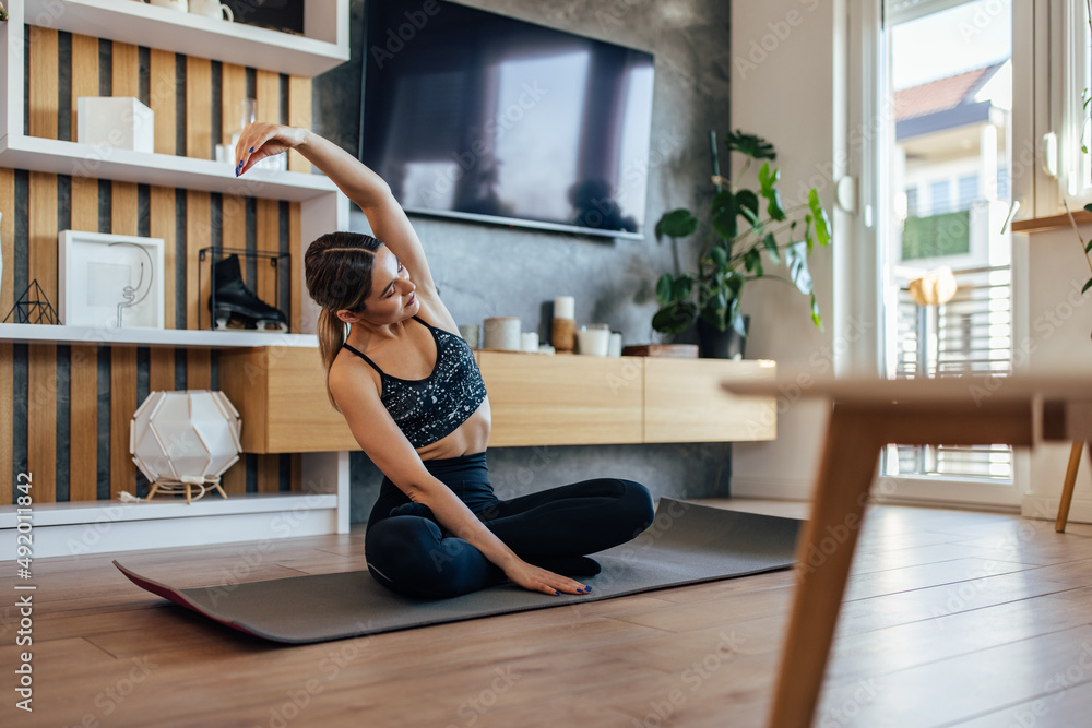 Young girl, dressed sporty, doing stretching.