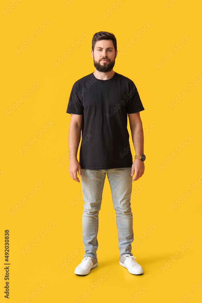 Handsome man in black t-shirt on yellow background