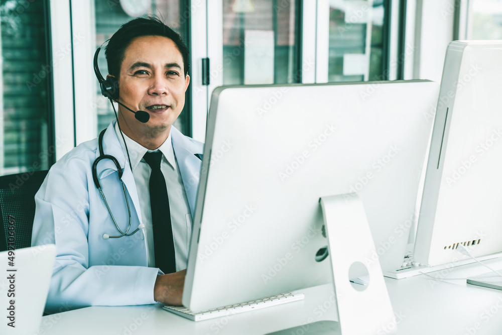 Doctor wearing headset talking actively on video call in a clinic or hospital . Concept of telehealt