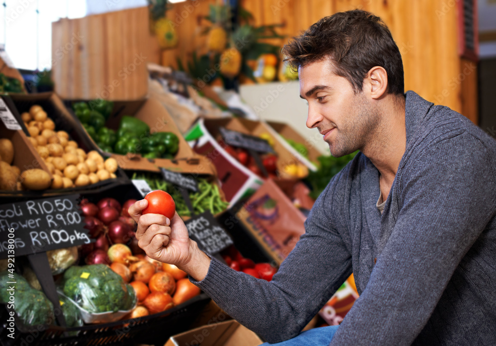 Only the freshest for him. Shot of a young man in a supermarket shopping for fresh produce.