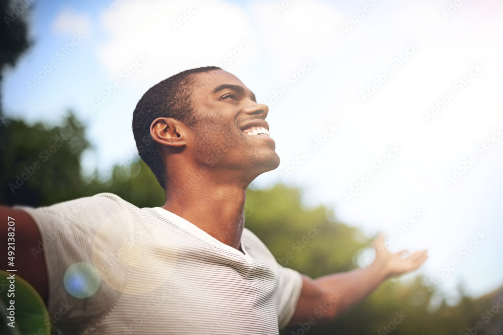 When life smiles at you, smile back. Shot of a man standing outside with his arms outstretched in de