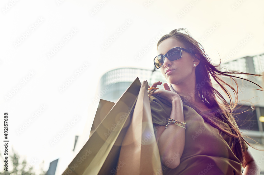 Fashionista on the move. A stylish young woman out shopping in the city.