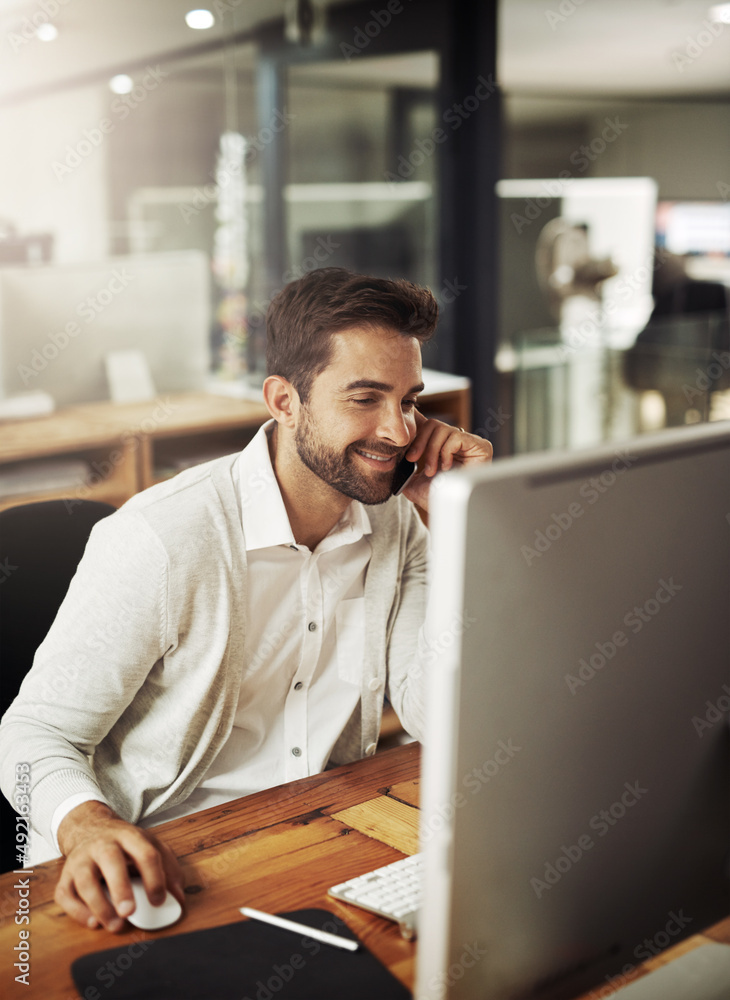 Forwarding updates while working late. Shot of a handsome young businessman talking on a cellphone w