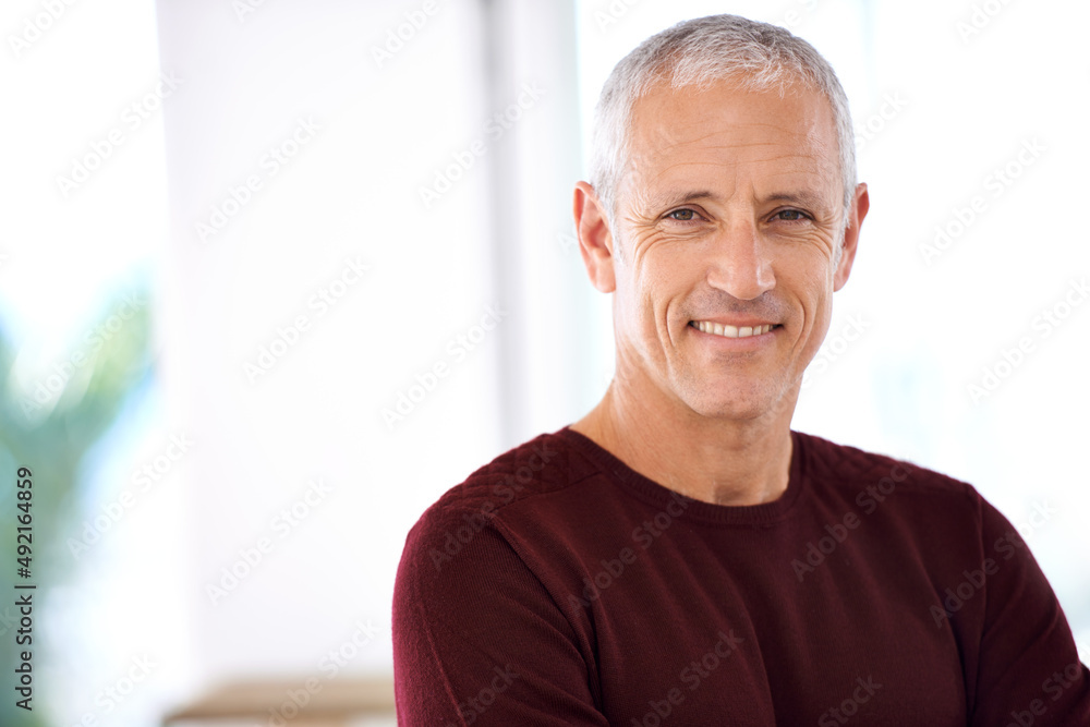 Confident and content. Portrait of a mature man standing in his home.