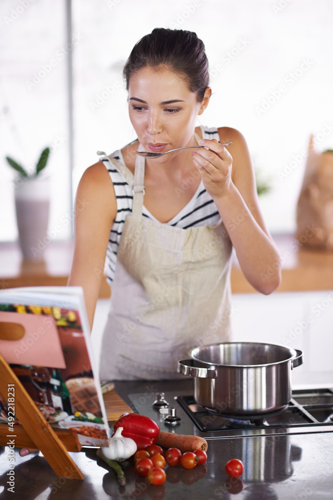 健康的生活味道很好。年轻女人在家做饭。